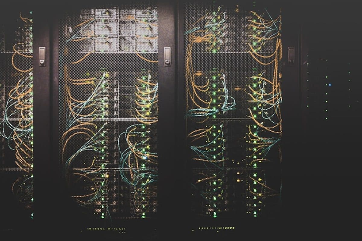Server racks and structured network cabling in a data centre, representing cloud and system architecture