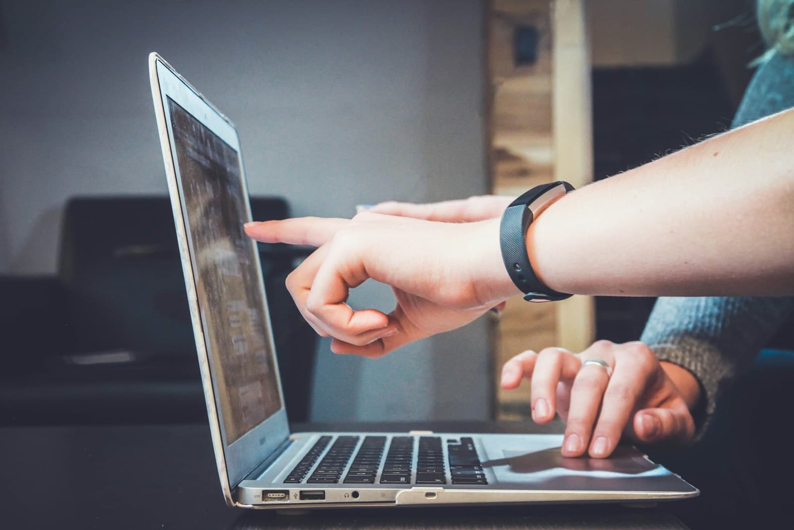 Developer reviewing code on a laptop alongside a teammate